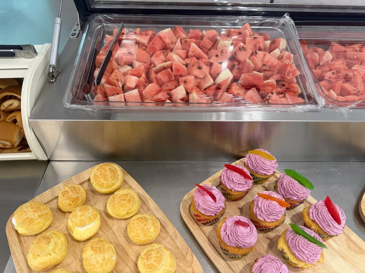Watermelon and cupcakes on a serving counter